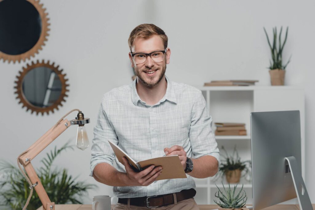 happy caucasian businessman writing in diary and s 77rdyda