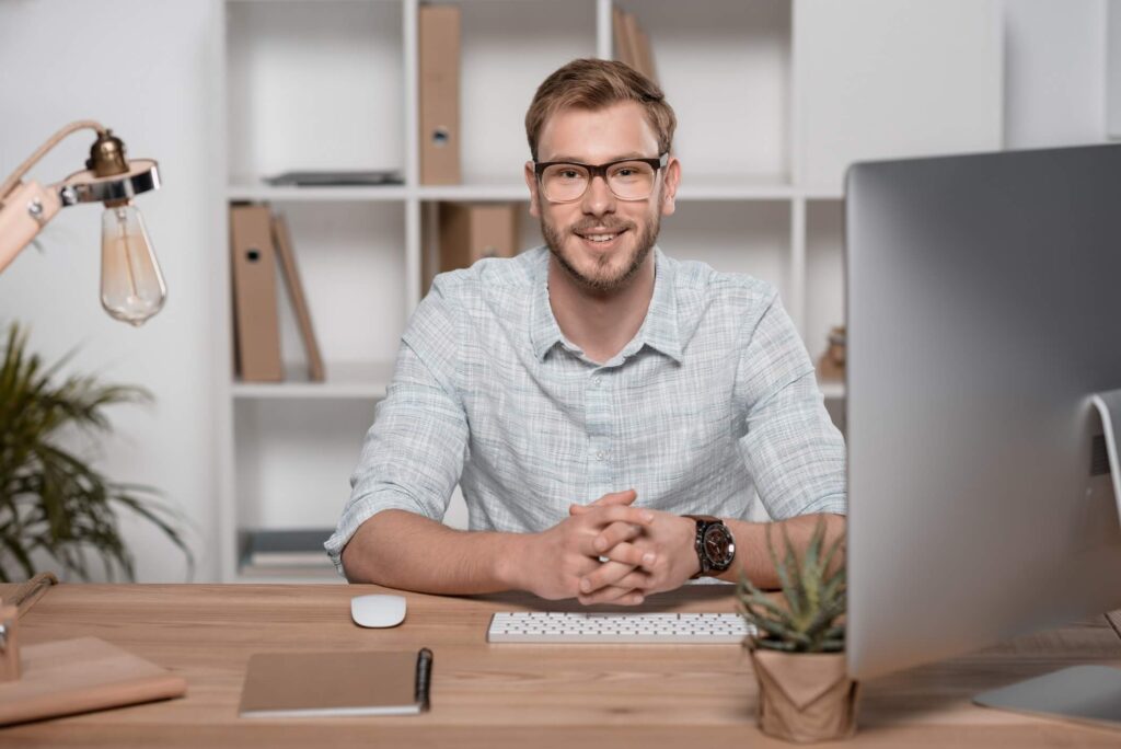 smiling caucasian bearded businessman sitting at w 3zlewpg